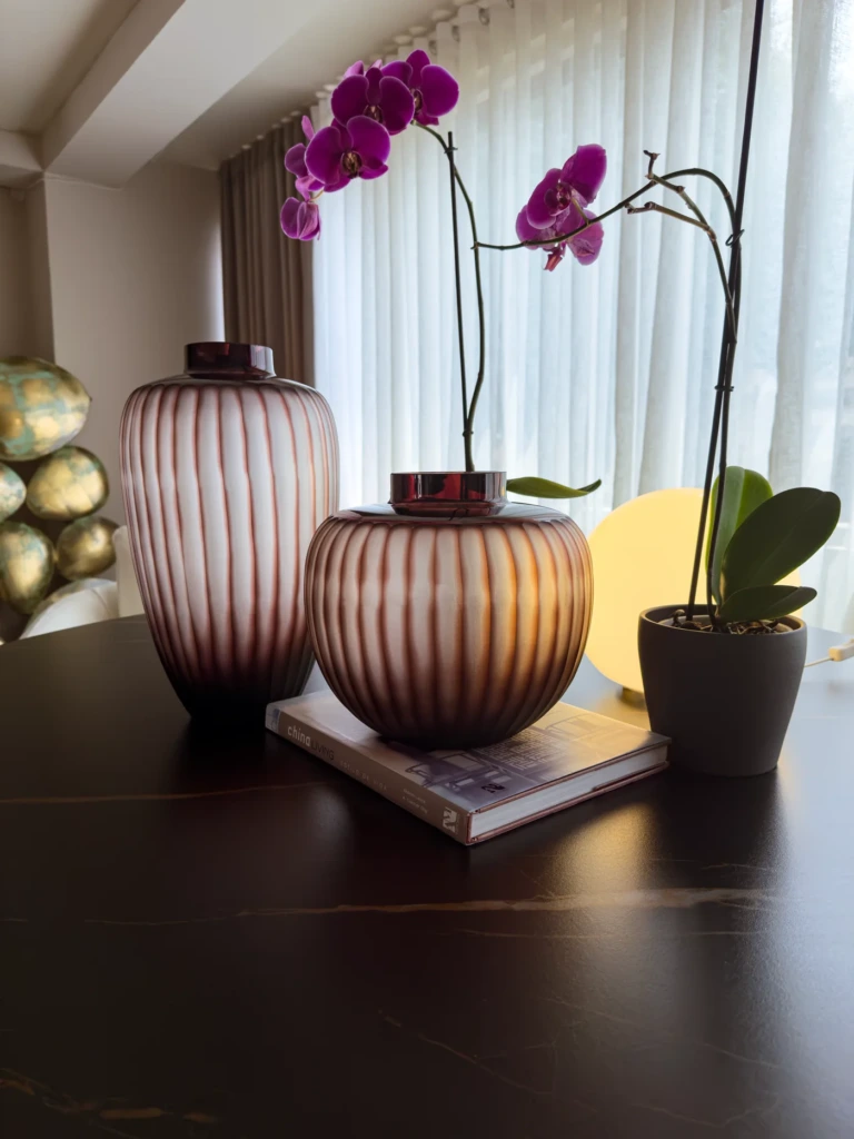 Jarrones de cristal soplado STAAD HOME sobre mesa oscura junto a una orquidea